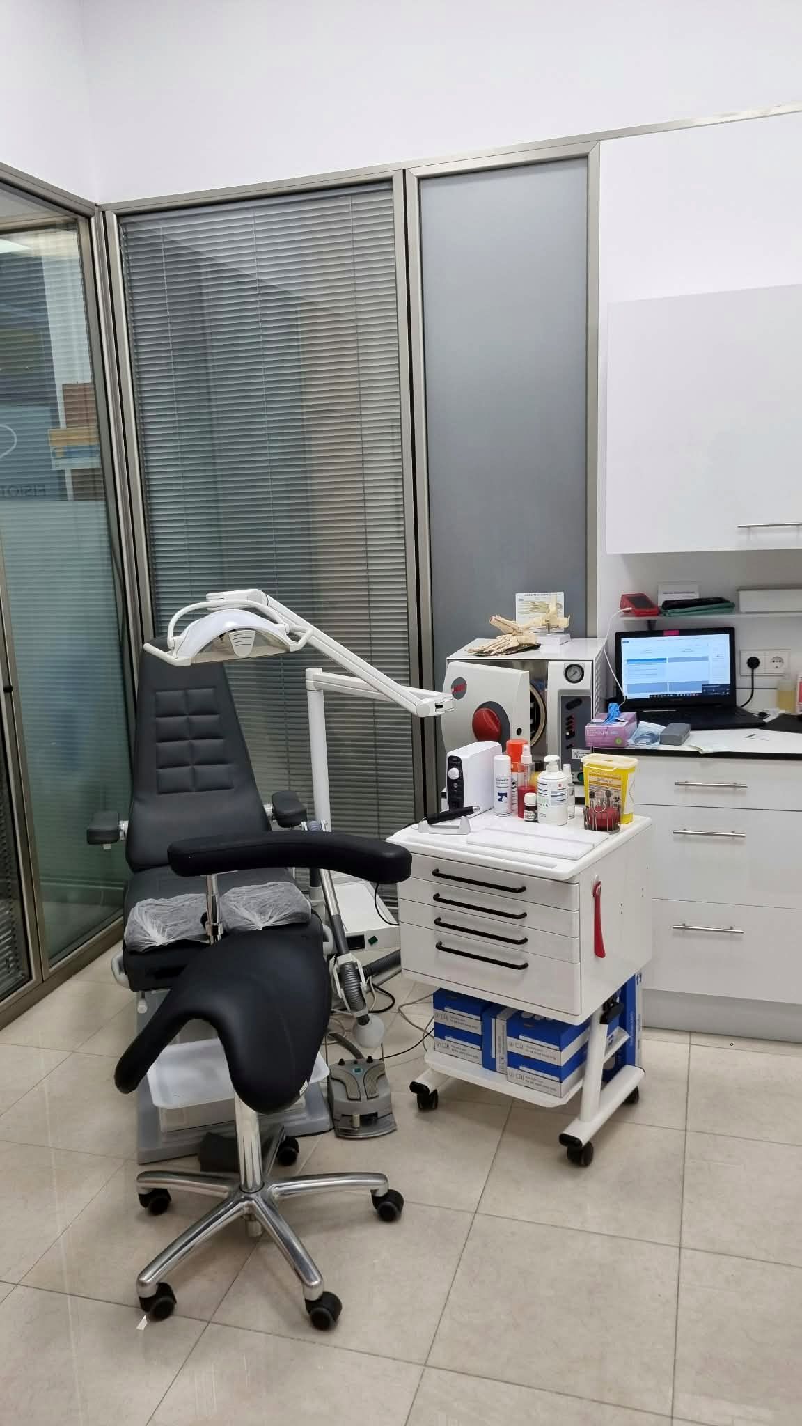 Consulta de podología con sillón clínico y carro de instrumental